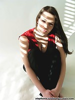 Steph poses in her red top in a studio