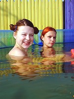 Two lesbian teens in a small pool