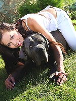 Young beautiful teen plays with her dog in the yard